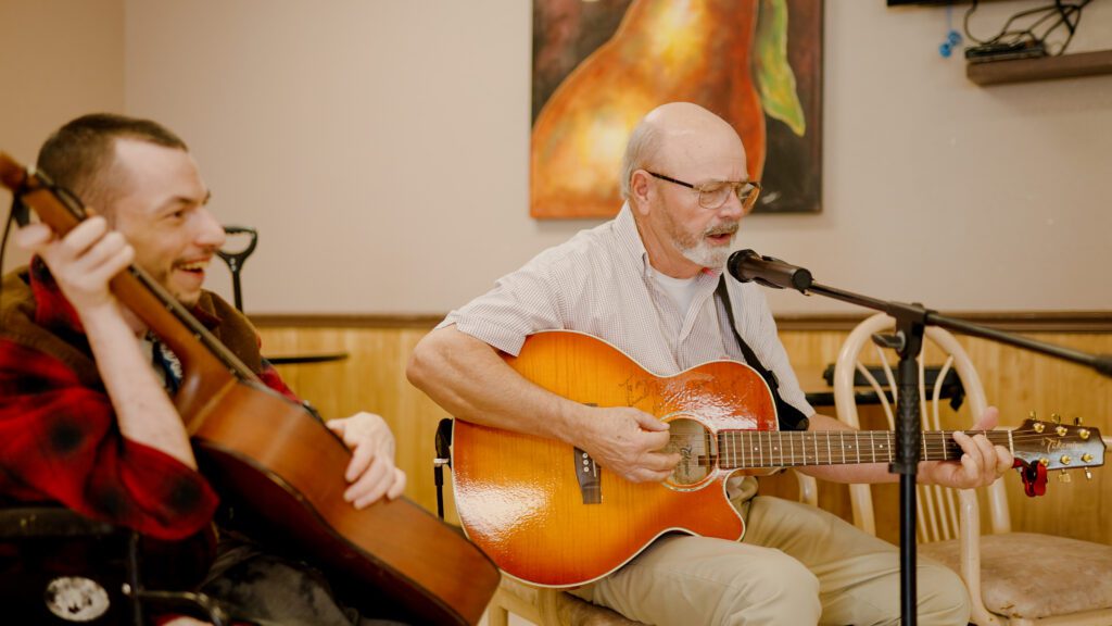 Two men at a skilled nursing facility participating in a music activity