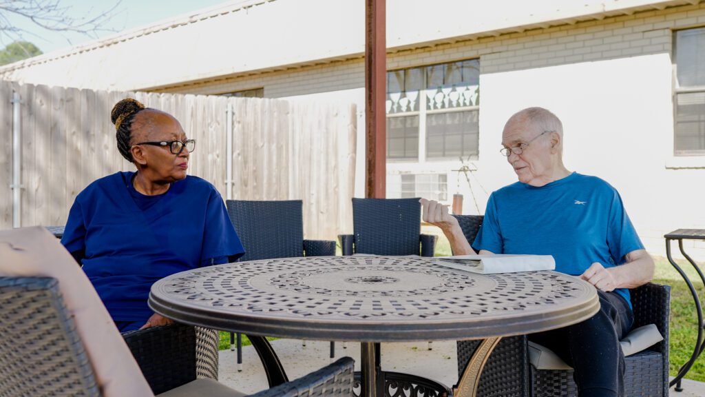 A man and a woman talk at a skilled nursing facility