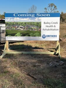 Coming Soon sign for the new Bailey Creek Health and Rehab skilled nursing facility at the Texarkana construction site.